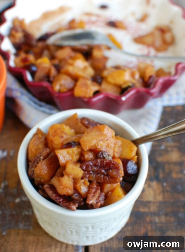 Close-up of Butternut Squash Apple Bake in a small serving bowl, highlighting the textures of squash, apples, raisins, and pecans.