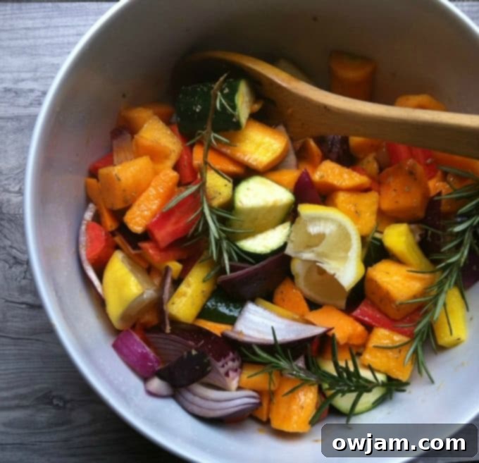 A rustic ceramic bowl brimming with warm Rosemary and Lemon Roasted Vegetables, highlighting the golden-brown edges and fresh herbs.