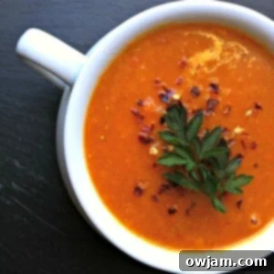 Velvety Coconut Lentil Bliss 5 Close-up of a bowl of Red Lentil Coconut Soup, garnished with herbs.