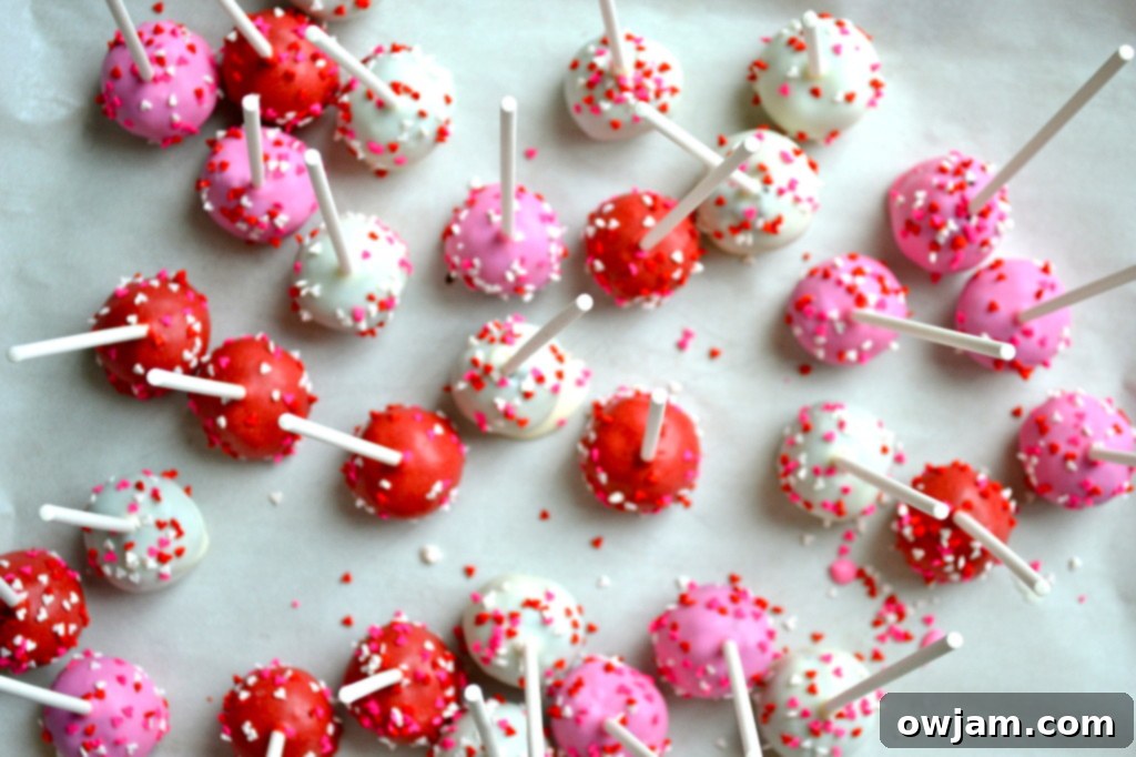 Close-up of freshly made Oreo cake pops decorated with vibrant pink and red sprinkles, ready to be served