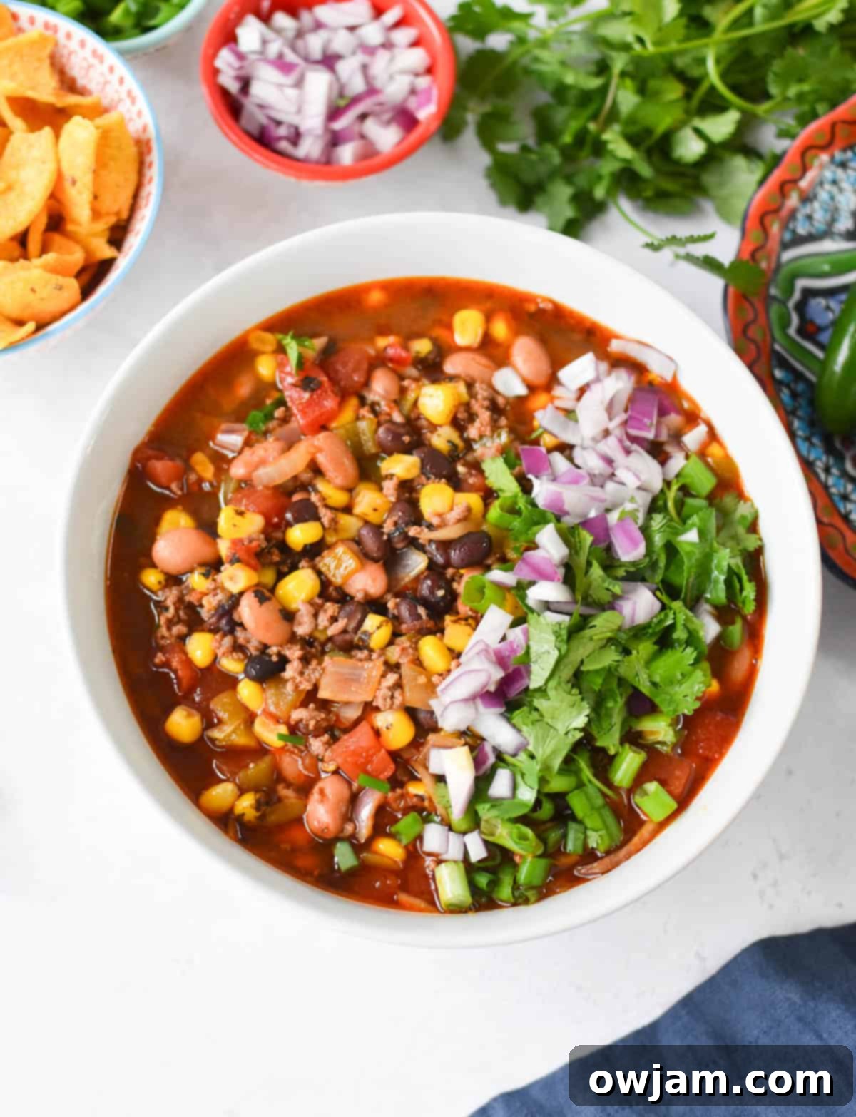 Slow Cooker Taco Soup Recipe in a white bowl with fresh toppings