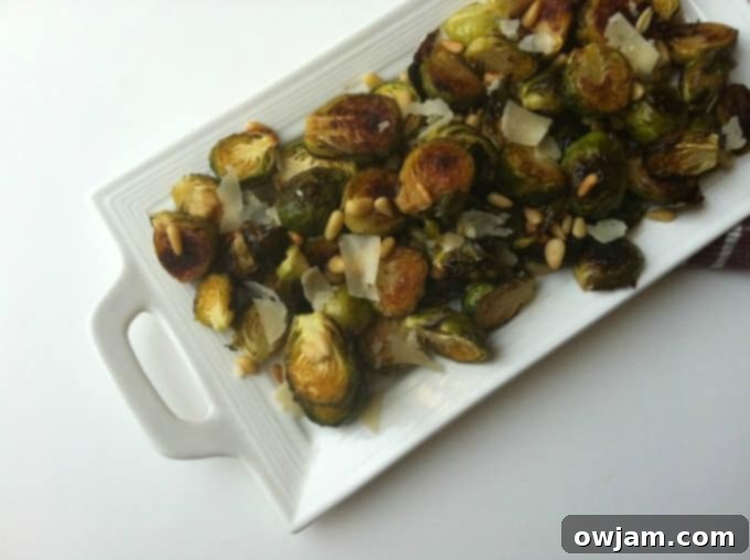 Crispy Lemon Roasted Brussels Sprouts with Pine Nuts and Parmesan on a white plate