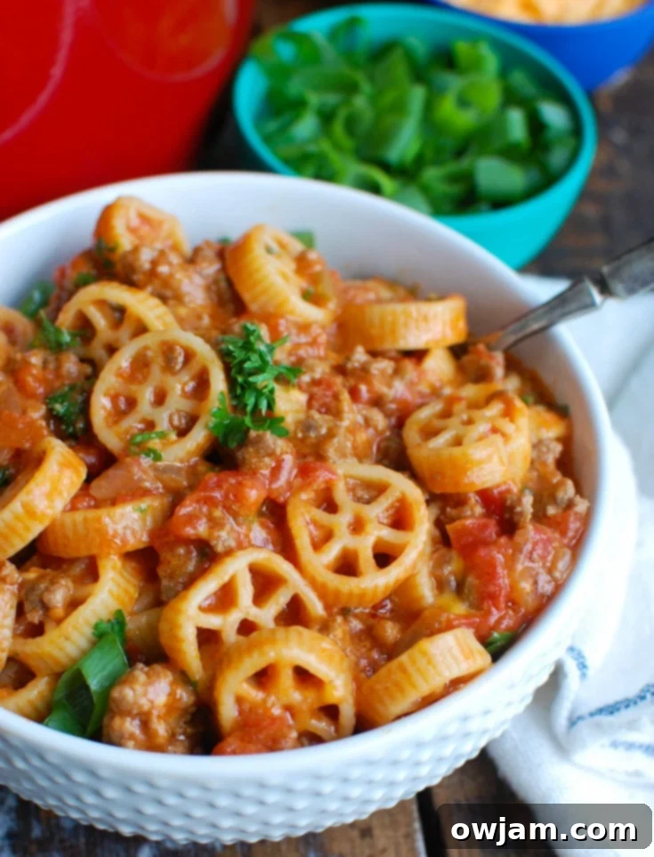 A close-up of One Skillet Cheesy Hamburger Pasta, a quick and easy one-pot meal with ground beef, tomatoes, cheese, and pasta, perfect for family dinners and delicious leftovers.
