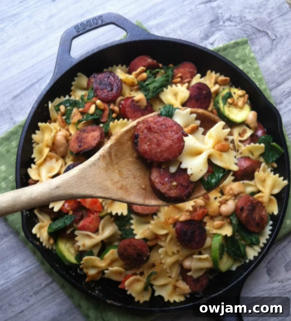 Hearty Smoked Sausage and White Bean Pasta 6 Smoked Sausage Pasta with White Beans served on a green napkin with a fork.