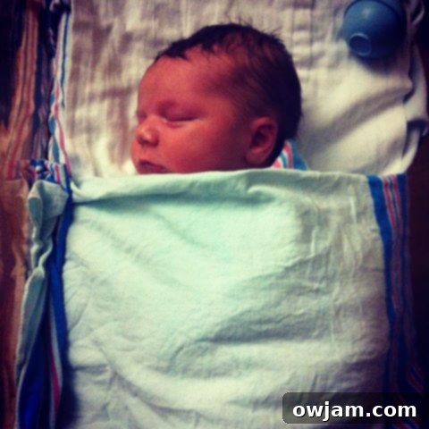 Newborn baby Andrew sleeping peacefully in a soft blanket