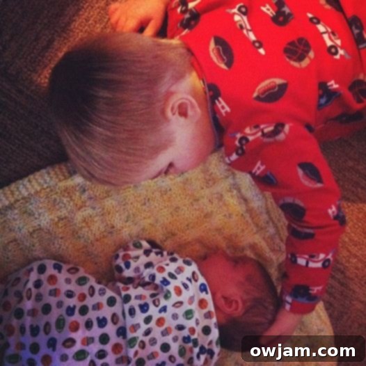 Big brother Will proudly holding baby Andrew with a gentle smile