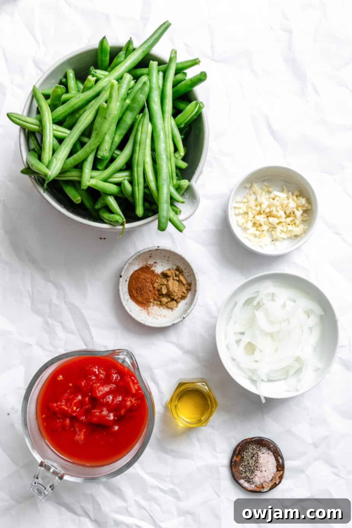 Lebanese Green Bean Stew 3 Fresh ingredients for Lebanese Green Beans (Lubee Bi Zeit) including green beans, diced tomatoes, onion, garlic, and a selection of fragrant spices.