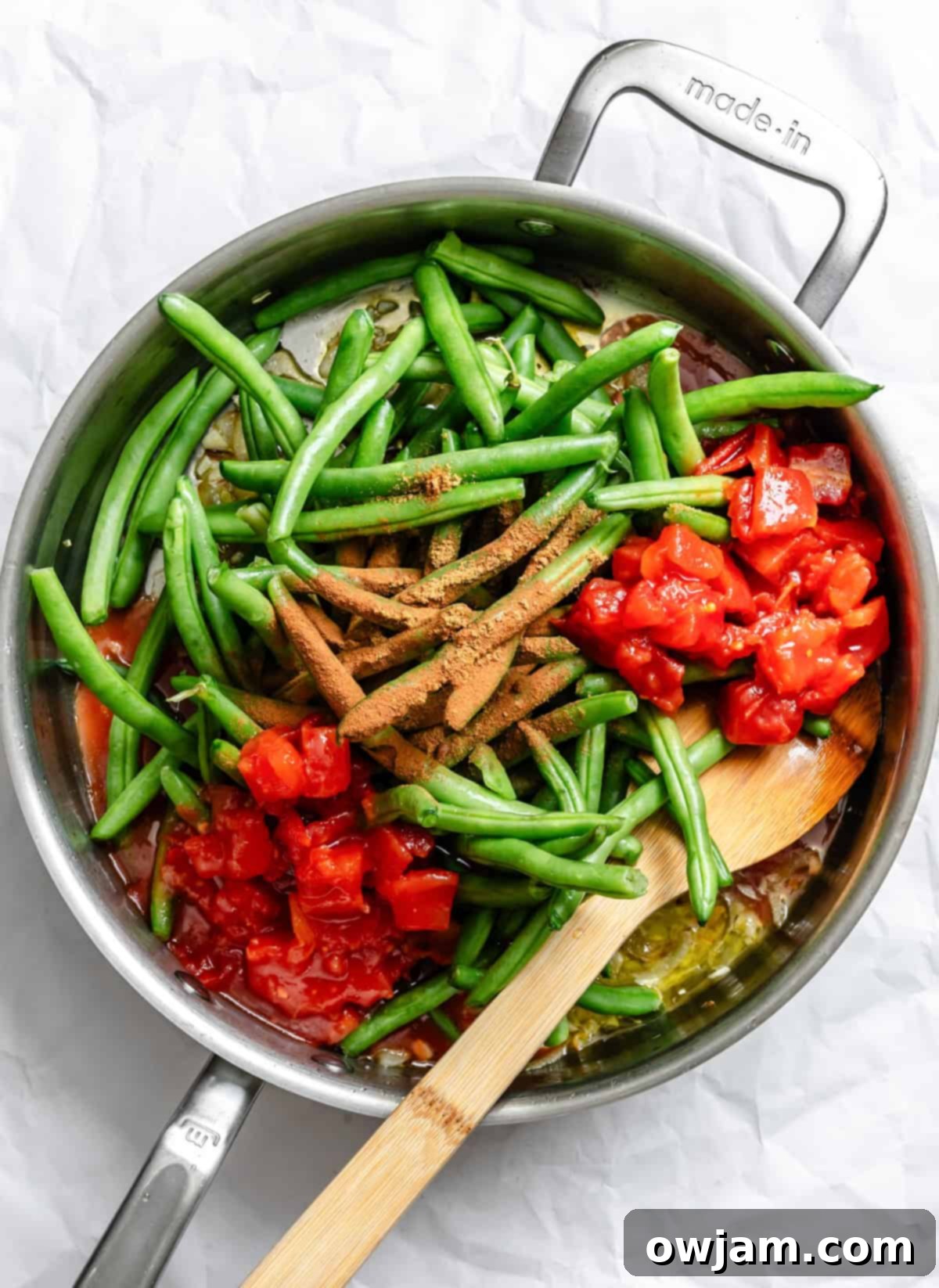 Lebanese Green Bean Stew 6 A close-up shot of Lebanese Green Beans (Lubee Bi Zeit) simmering perfectly in a large skillet, with rich tomato sauce and visible green beans.