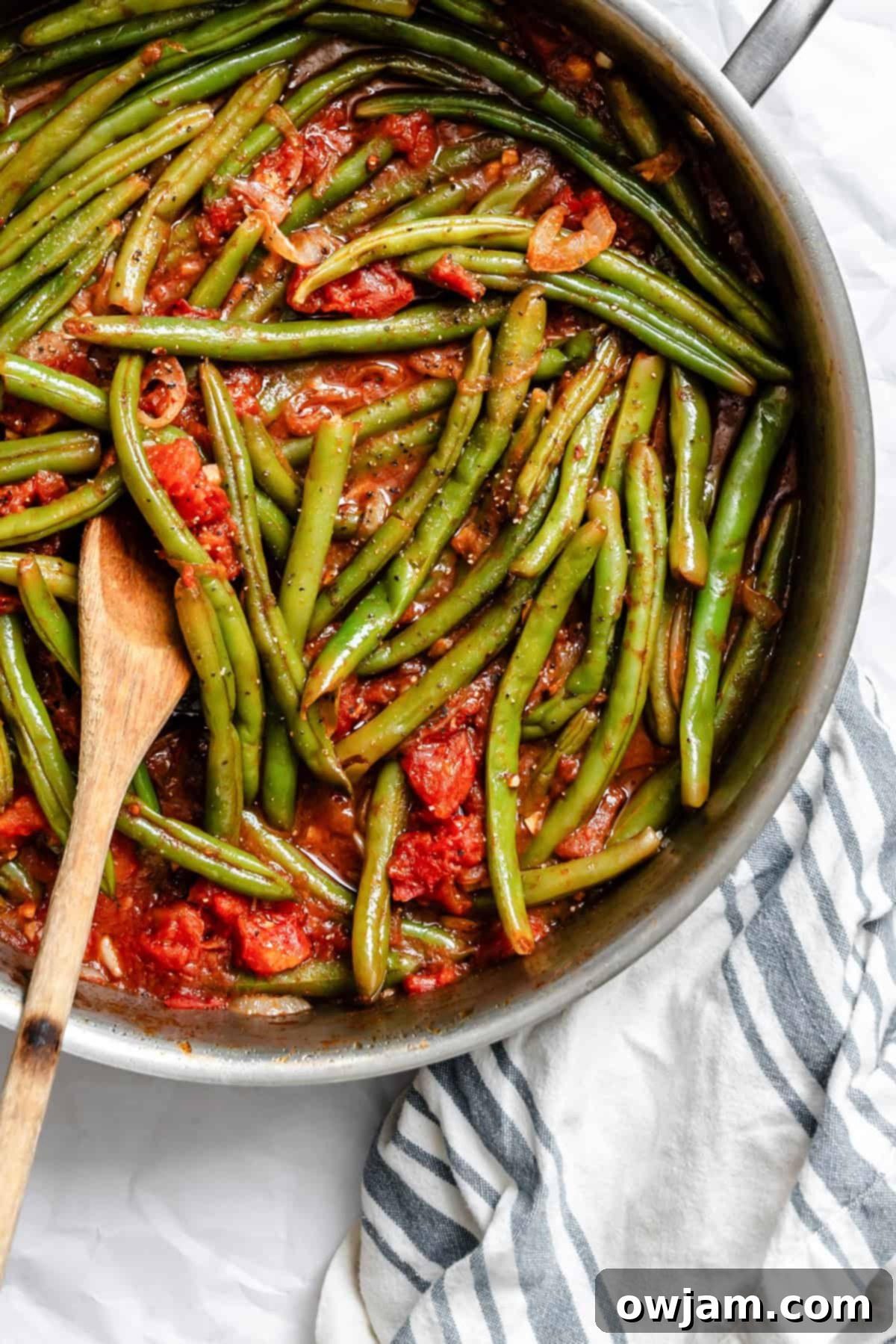 Lebanese Green Bean Stew 7 A large skillet brimming with freshly cooked Lebanese Green Beans (Lubee Bi Zeit), showcasing the tender green beans in a rich tomato and spice sauce, ready for serving.