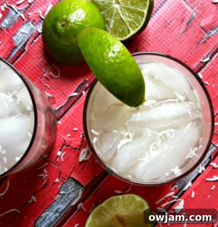 Spiked Raspberry Lime Coconut Water Cocktail Garnished with Fresh Coconut