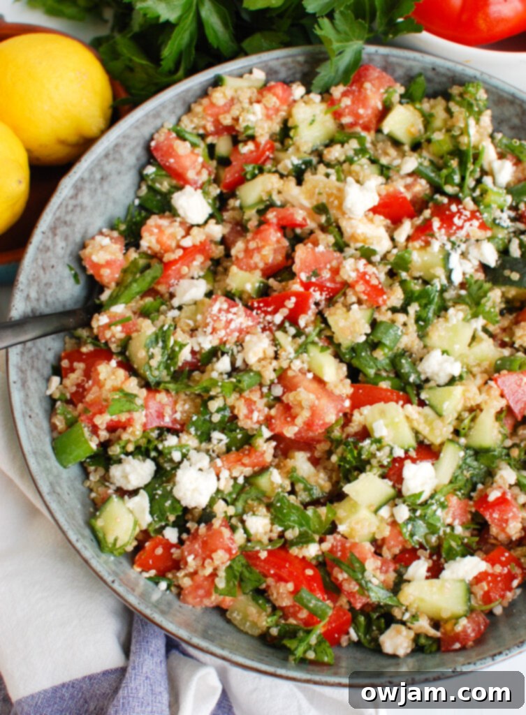 Tomato Cucumber Feta Quinoa Salad with spoon in a large serving bowl