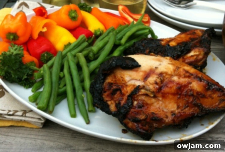 Spiced Honey Lime Grilled Chicken on a white plate with a side of greens