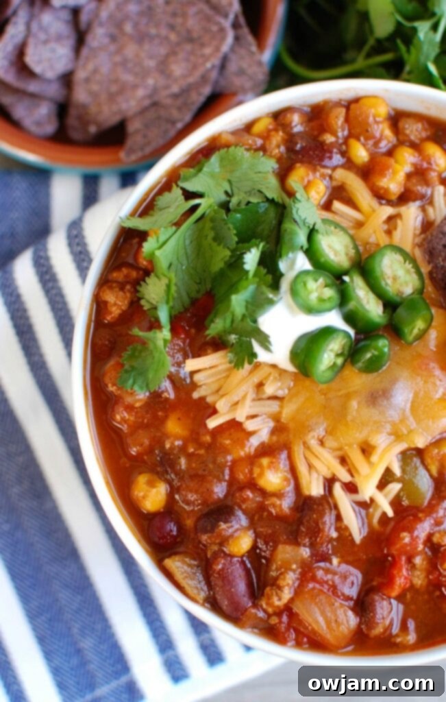 Overhead view of Slow Cooker Turkey Chili in a white bowl with a spoon