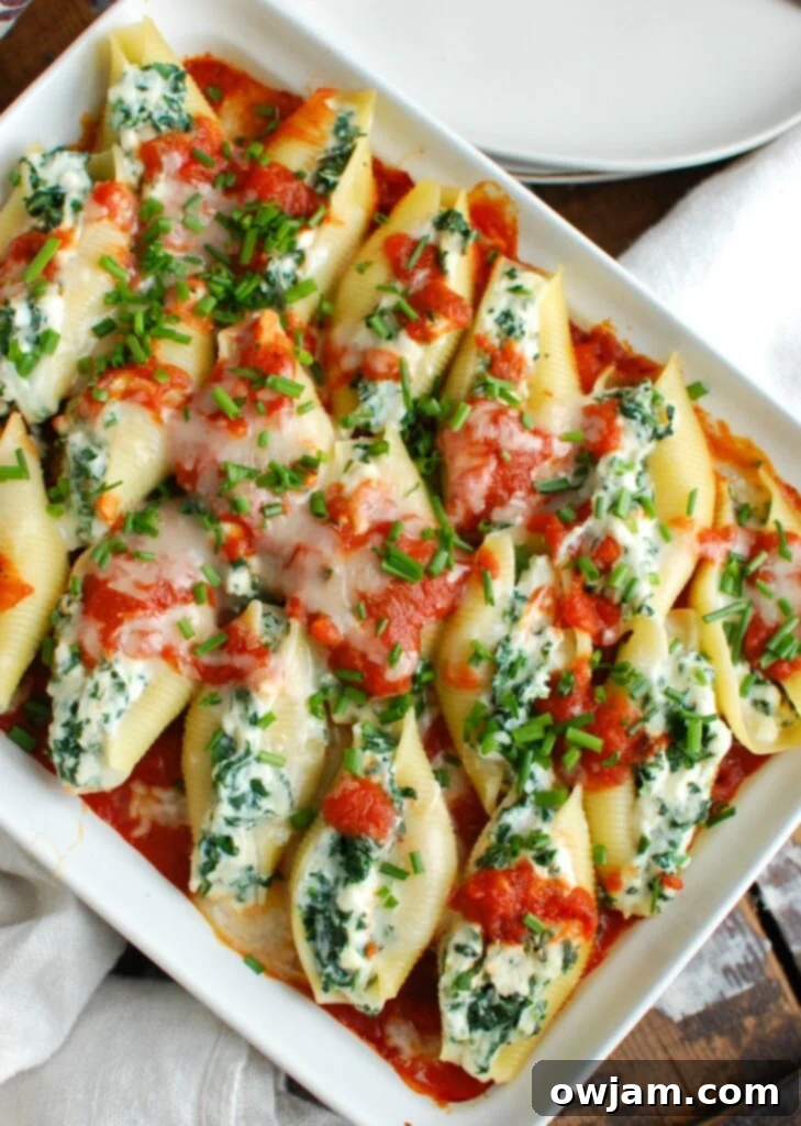 Delicious Stuffed Shells 4 Hand stuffing a jumbo pasta shell with creamy cheese mixture before baking.