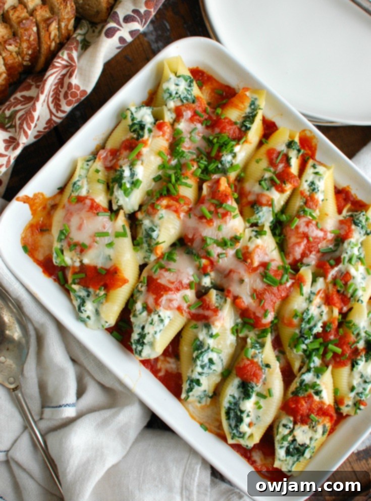 Delicious Stuffed Shells 5 Baked Stuffed Shells in a white rectangular baking pan, garnished with fresh herbs.