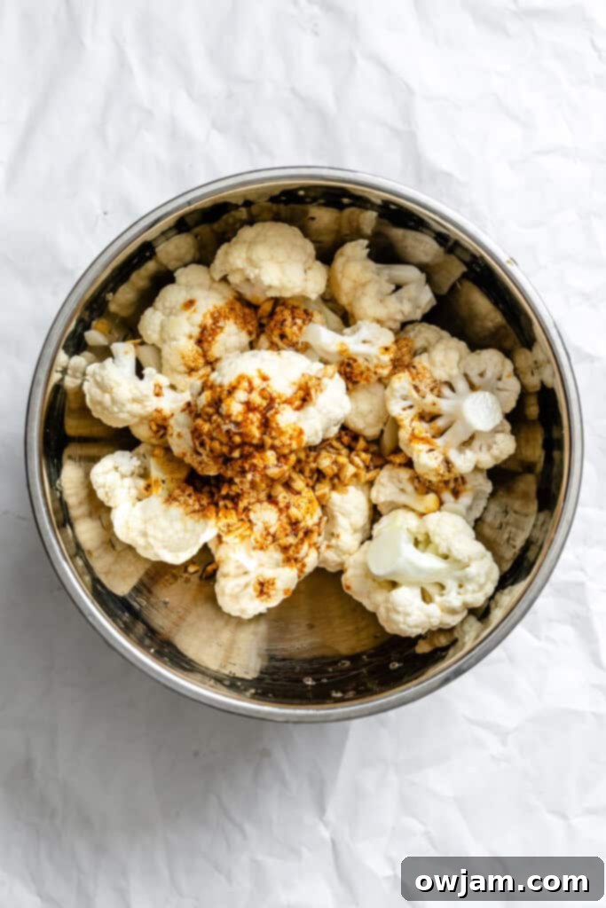 Golden Curry Roasted Cauliflower 7 Cauliflower florets in a mixing bowl, generously coated with curry spices and olive oil