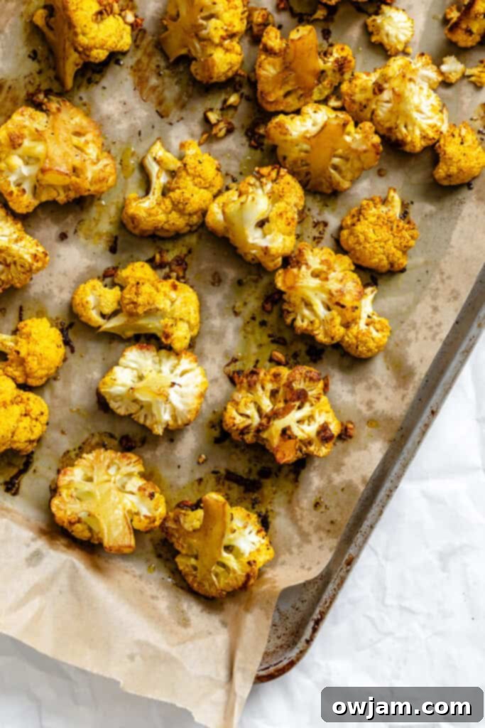Golden Curry Roasted Cauliflower 8 Curry Roasted Cauliflower spreading on a baking sheet, ready for the oven