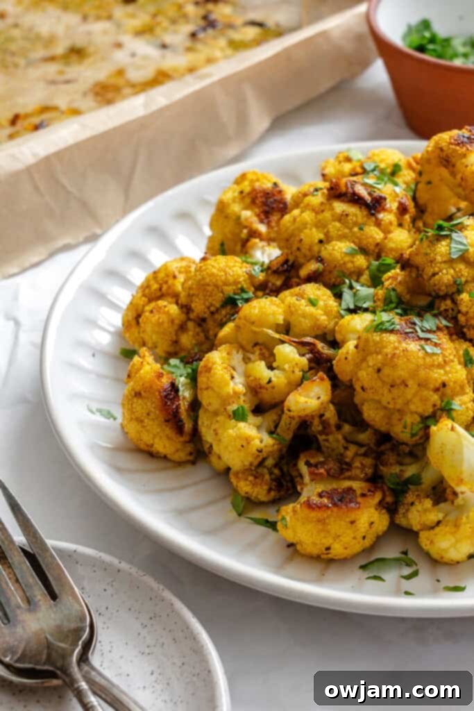 Golden Curry Roasted Cauliflower 9 Curry Roasted Cauliflower on a plate, garnished with fresh cilantro
