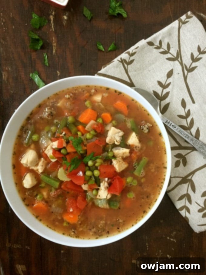 A steaming bowl of healthy Chicken Quinoa Soup garnished with fresh parsley, ready to be enjoyed.