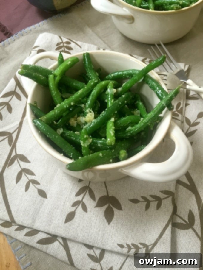 Close-up of vibrant green beans coated in garlic and parmesan, ready to be served.