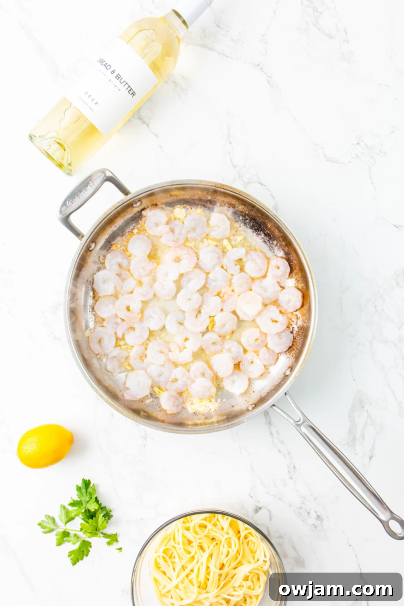 Zesty Lemon Garlic Shrimp Pasta 7 Shrimp cooking in a skillet with garlic and onion for Lemon Garlic Shrimp Pasta.