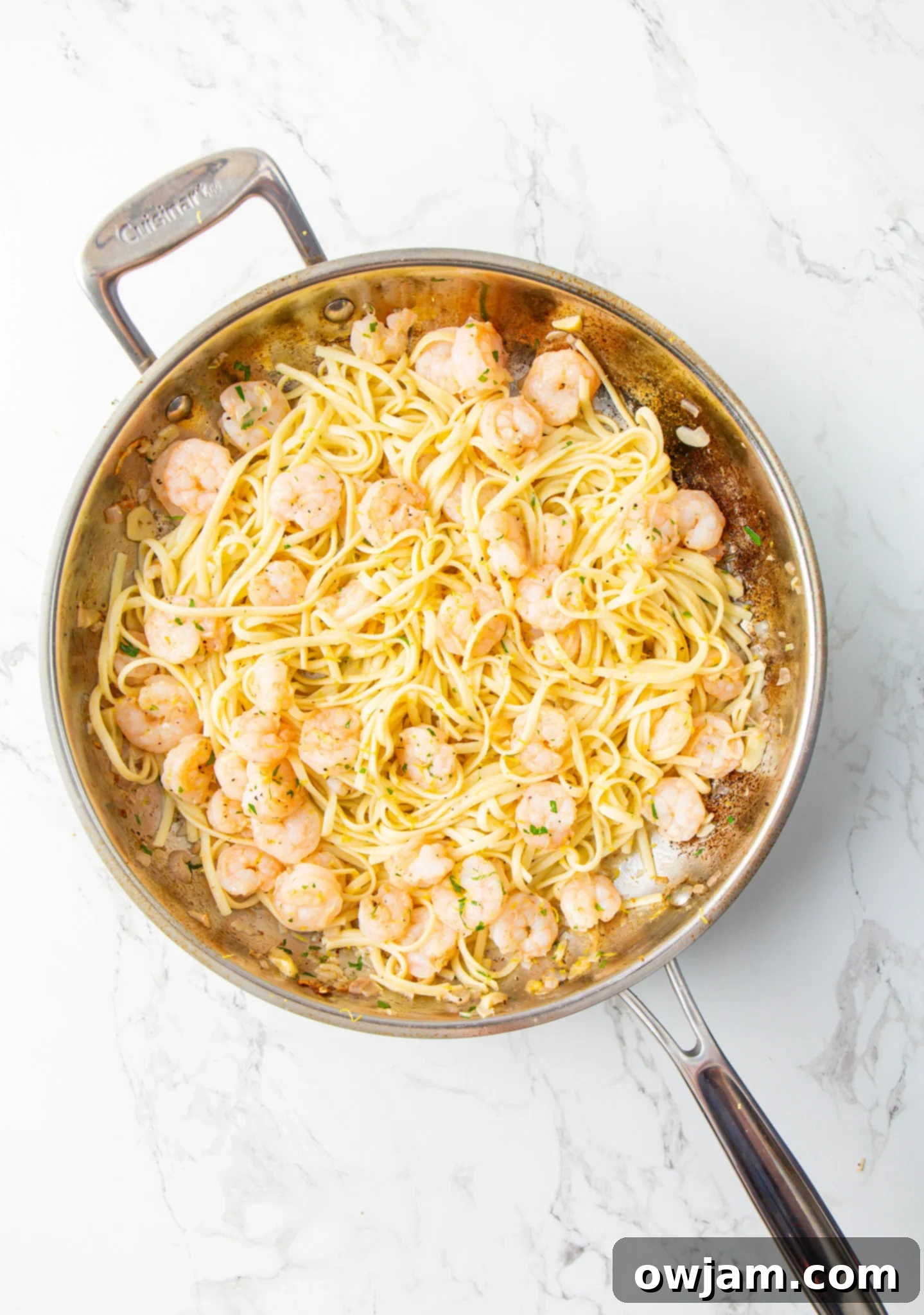 Zesty Lemon Garlic Shrimp Pasta 8 Lemon Garlic Shrimp Pasta being tossed in a skillet, showcasing the delicious sauce and ingredients.