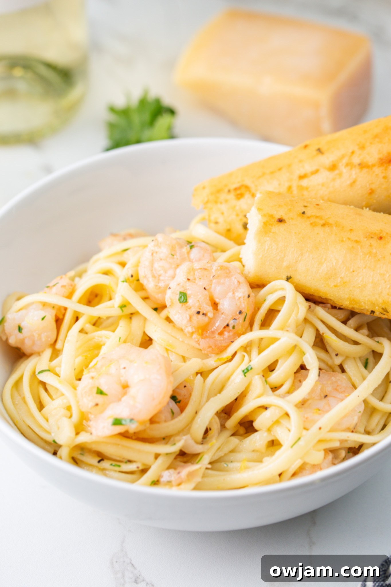 Zesty Lemon Garlic Shrimp Pasta 9 Lemon Garlic Shrimp Pasta in a bowl with a breadstick, ready to enjoy.
