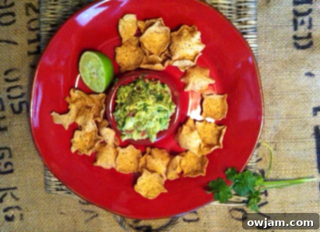 Close-up shot of a bowl of guacamole with a side of chips, illustrating its party-ready appeal.