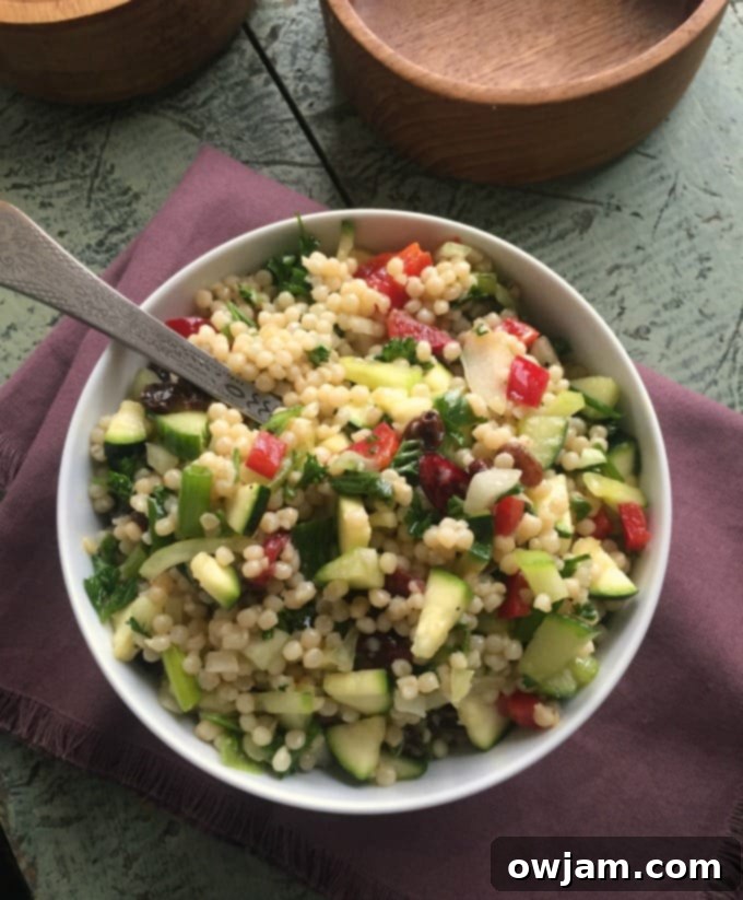 Zesty Pearl Couscous Salad 5 A bowl of Israeli Couscous Salad with Lemon Dressing, garnished with fresh herbs and lemon wedges