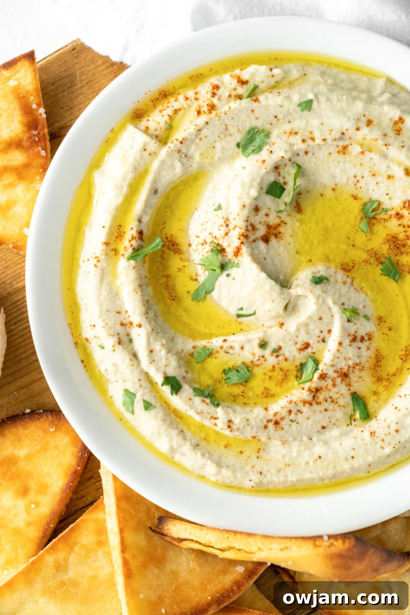 Creamy Baba Ghanoush served in a white bowl, garnished with fresh parsley and a drizzle of olive oil.