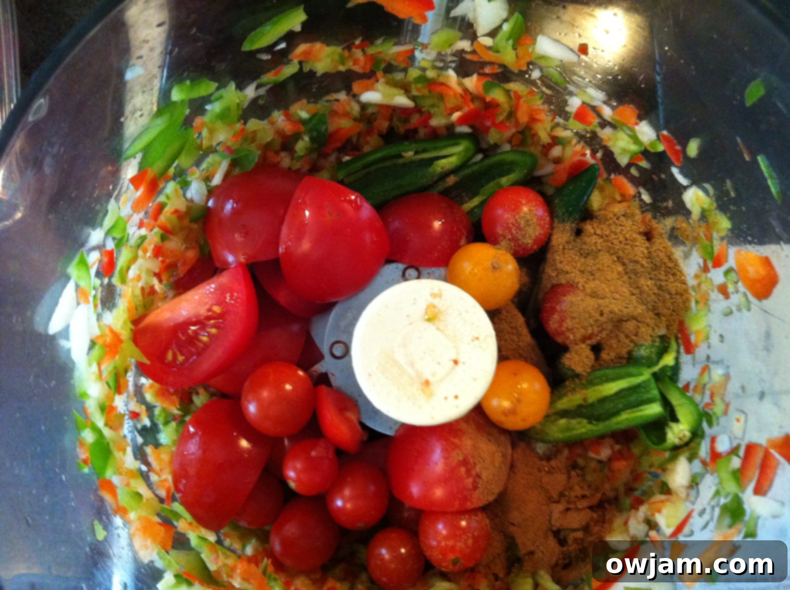 Diced tomatoes and other fresh vegetables in a food processor, ready for Kickin' Salsa