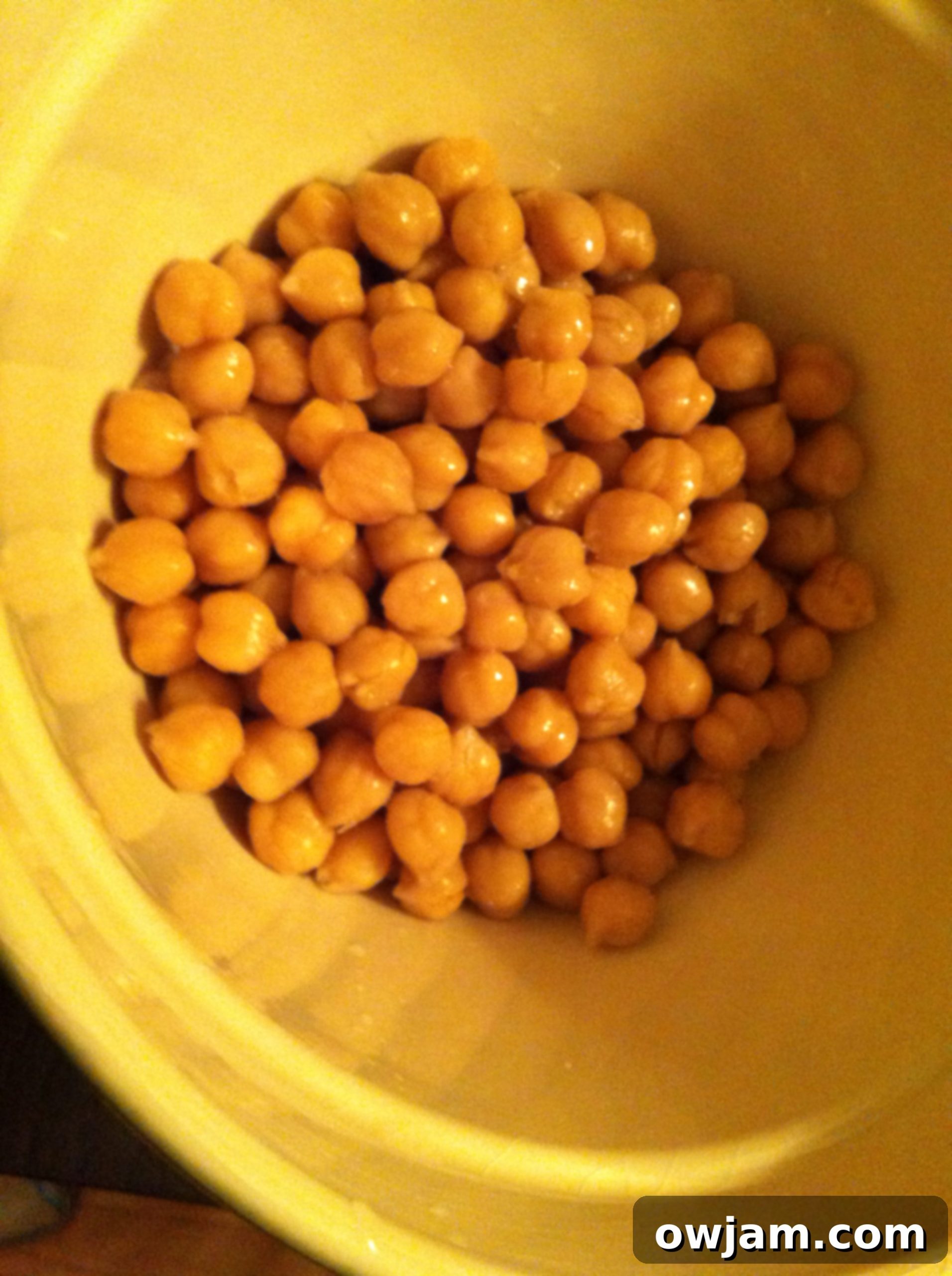 Drained and rinsed chickpeas in a mixing bowl, ready for seasoning.