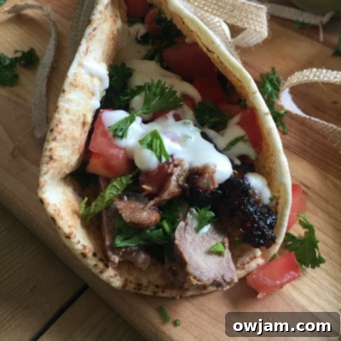 Mediterranean Steak Pita Wrap with Mint Yogurt Sauce on cutting board. 