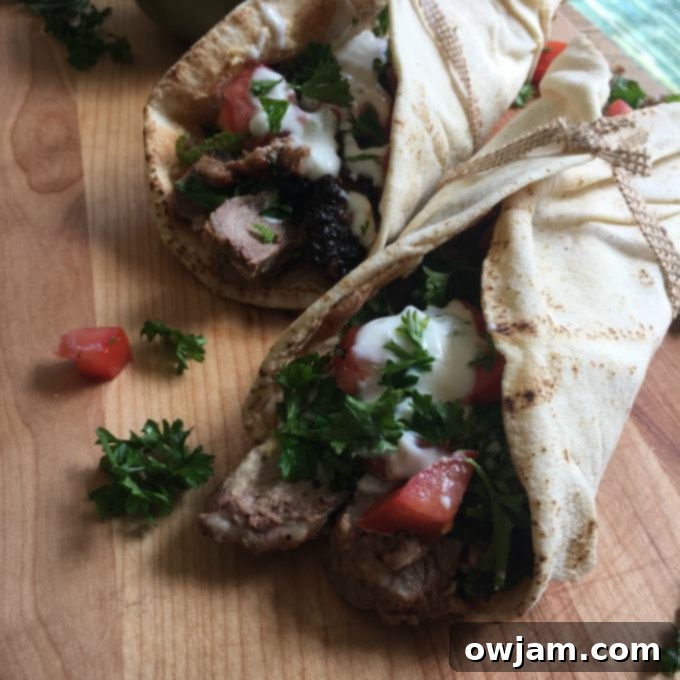 Mediterranean Steak Pita Wrap with Mint Yogurt Sauce on cutting board. 