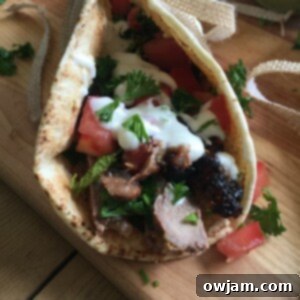 Mediterranean Steak Pita Wrap with Mint Yogurt Sauce on cutting board.