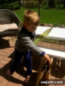 Child smiling while husking corn