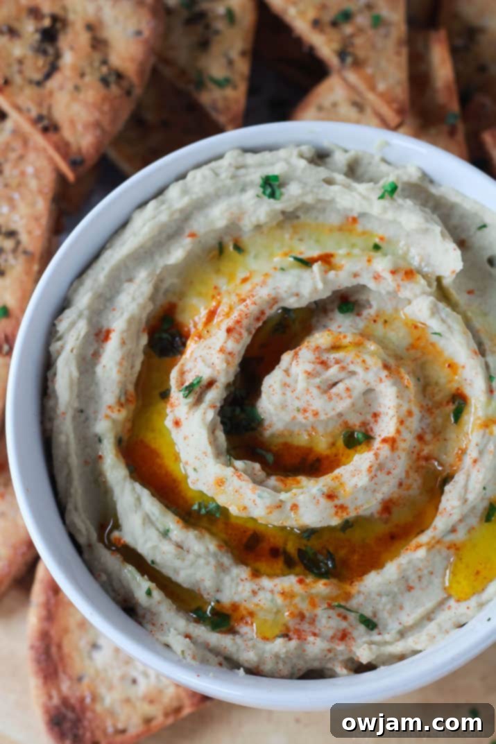 Roasted Garlic White Bean Hummus in a serving bowl, garnished with herbs