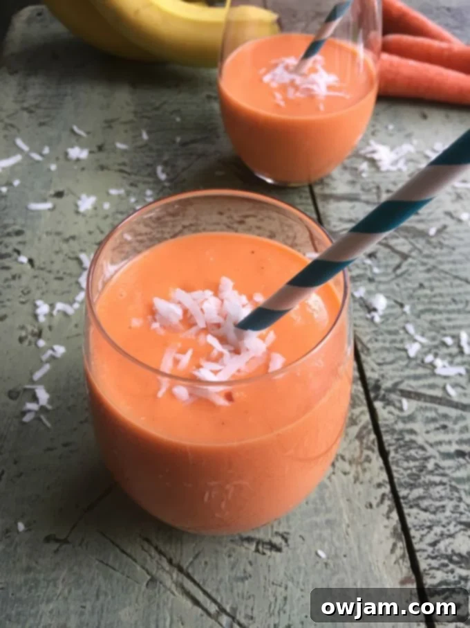 Golden Carrot Delight 2 Close-up of a refreshing Coconut Carrot Smoothie in a glass, garnished with shredded coconut.
