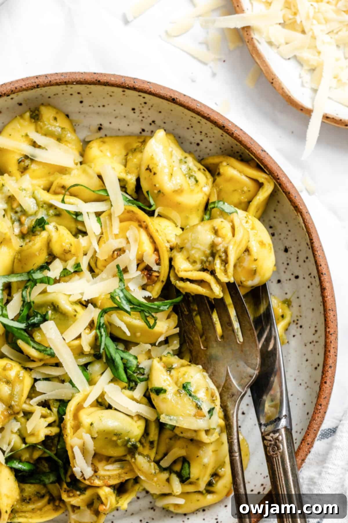 Speedy Cheesy Pesto Tortellini Dinner 12 tortellini in a bowl with a fork and knife