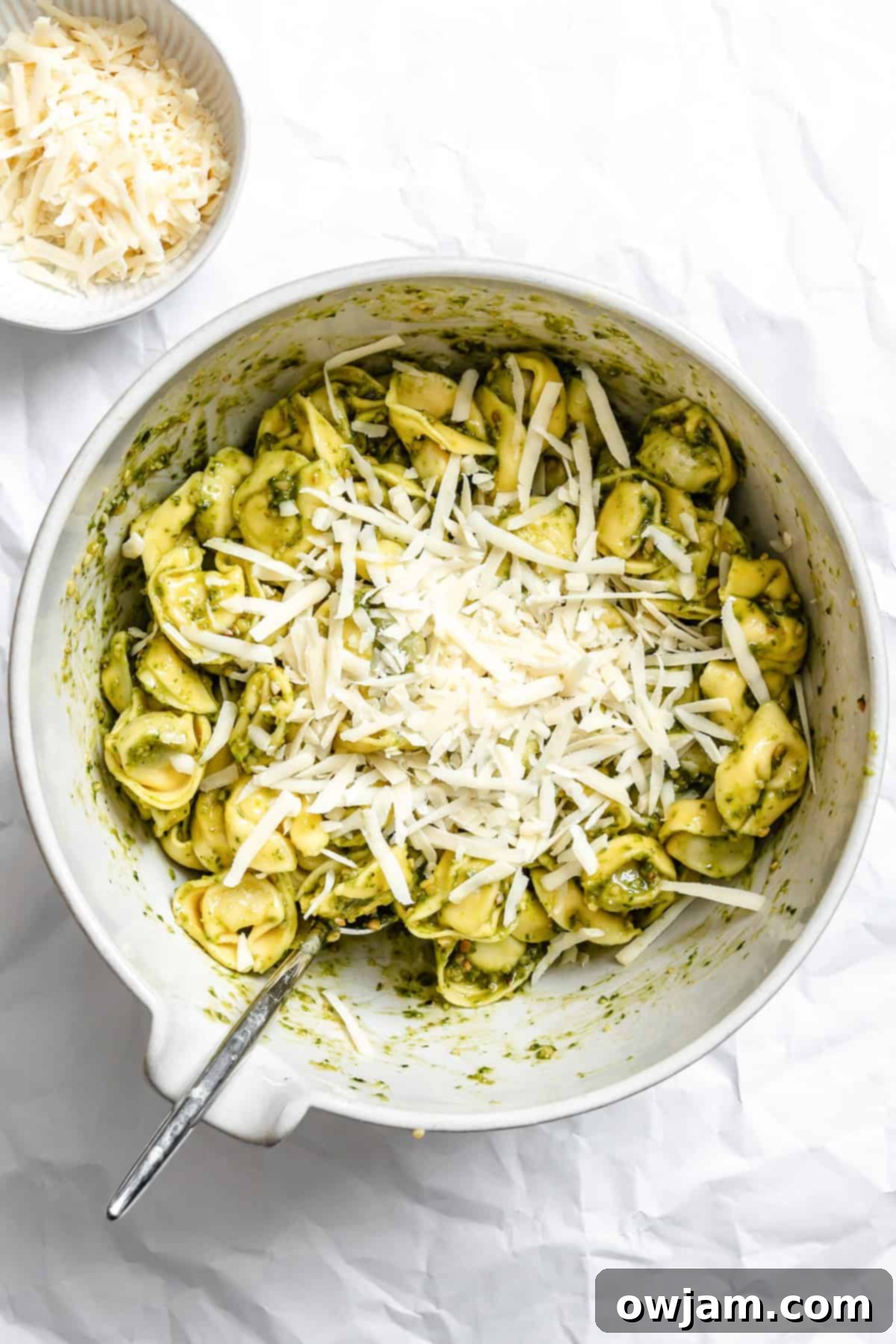 Speedy Cheesy Pesto Tortellini Dinner 7 tortellini in a large bowl mixed with pesto and cheese