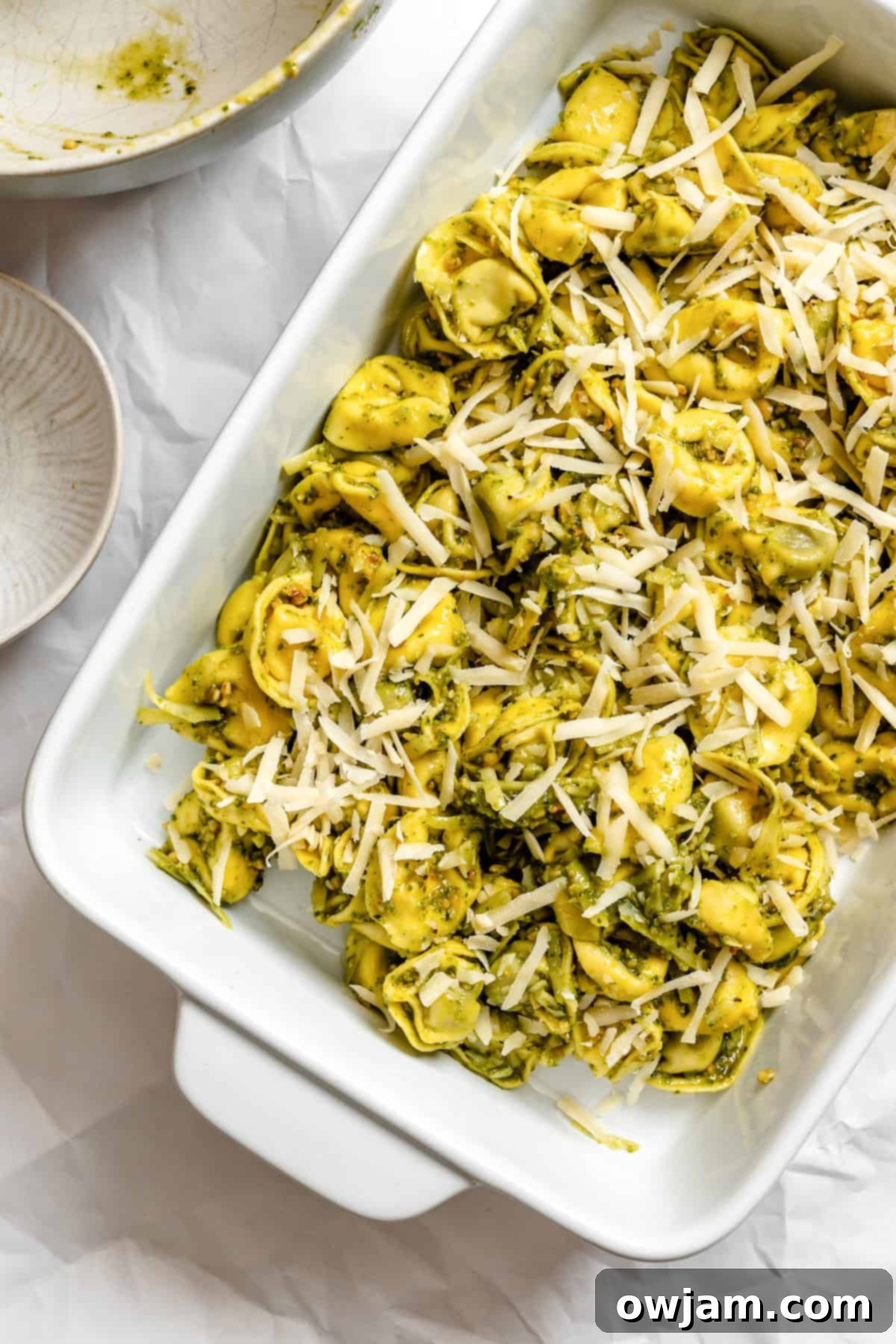 Speedy Cheesy Pesto Tortellini Dinner 8 Pesto Tortellini in a baking dish with cheese