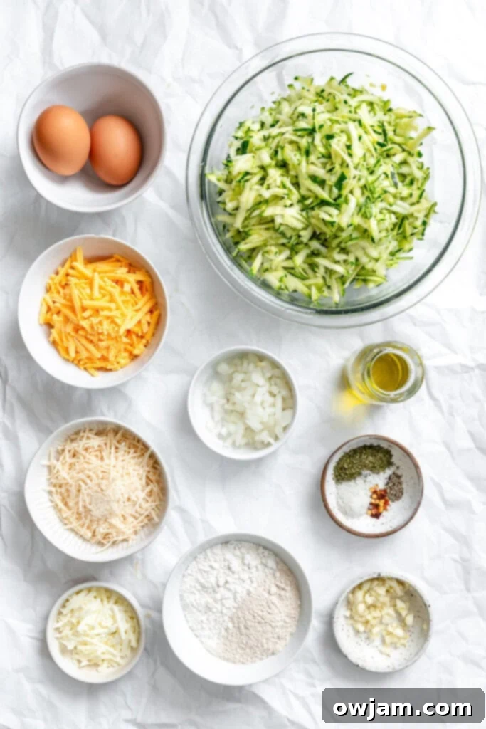 Effortless Zucchini Fritters 3 Essential ingredients for Easy Zucchini Fritters laid out, including zucchini, eggs, various cheeses, and spices.