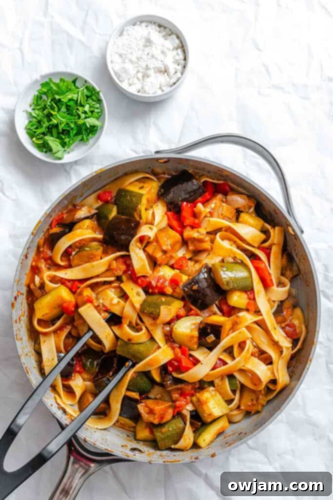 Pappardelle pasta being tossed with the homemade Ratatouille sauce in a pan.