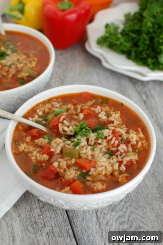 Slow Cooker Deconstructed Stuffed Pepper Soup 4 Close-up of a spoonful of rich Slow Cooker Stuffed Pepper Soup with rice and vegetables.