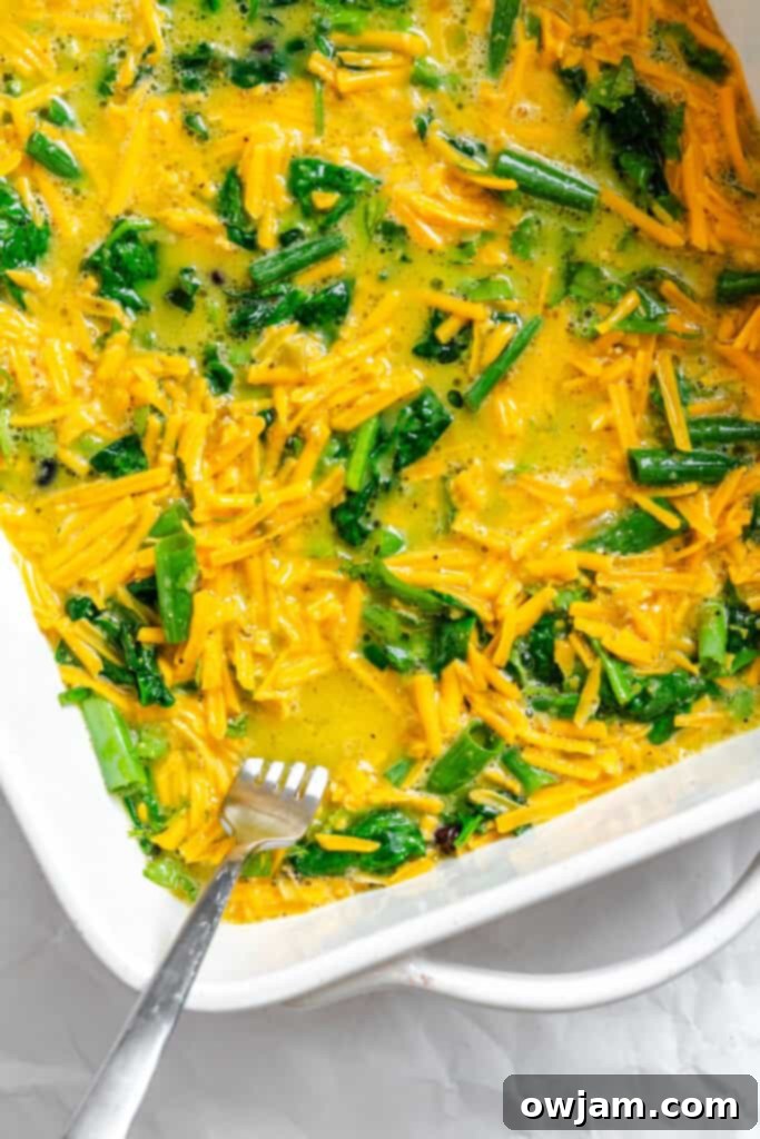 Cheesy Black Bean Egg Bake eggs poured over ingredients in baking dish