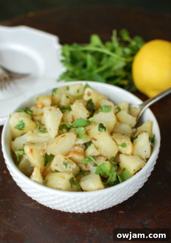 Golden-brown lemon cilantro roasted potatoes in a bowl, garnished with fresh cilantro.