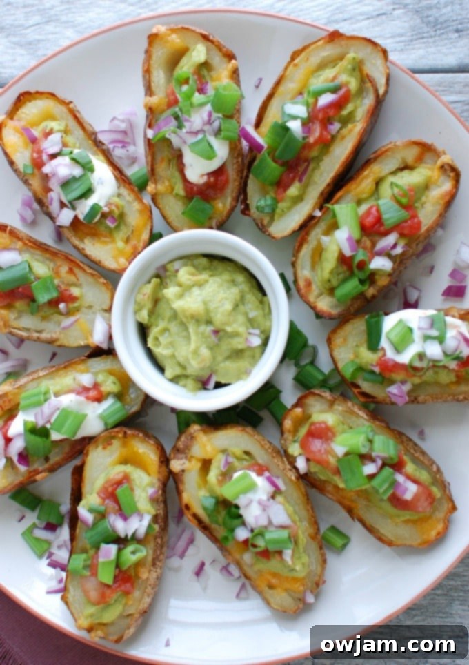 Loaded Guacamole Potato Skins 2 Guacamole Stuffed Potato Skins on white platter, showcasing the crispy skins and vibrant green guacamole topping