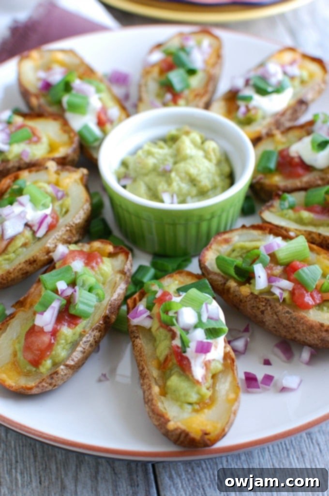 Loaded Guacamole Potato Skins 3 Close-up of a single Guacamole Stuffed Potato Skin on a white plate, showing the texture of the guacamole and melted cheese