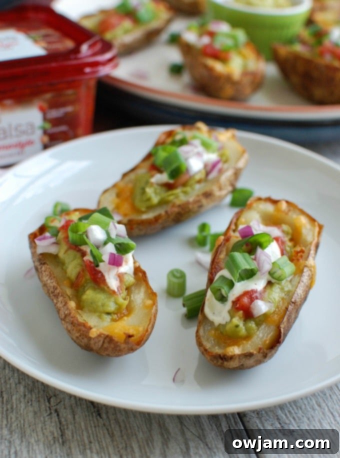 Loaded Guacamole Potato Skins 7 Three Guacamole Stuffed Potato Skins on a plate, garnished with green onions and a squeeze of lime