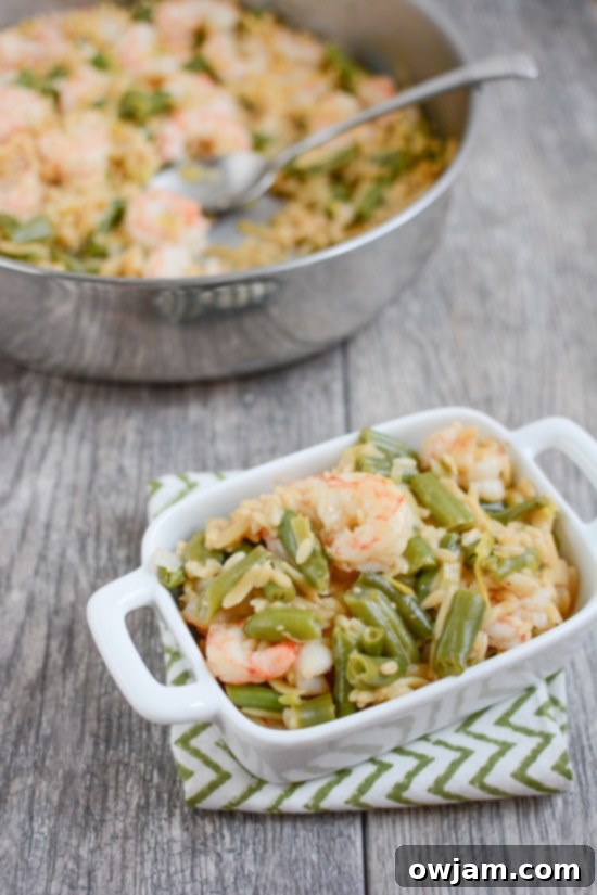 A simple yet flavorful one-pot shrimp and orzo dish, cooked with succulent tomatoes and fresh spinach, and elegantly garnished with aromatic fresh herbs.